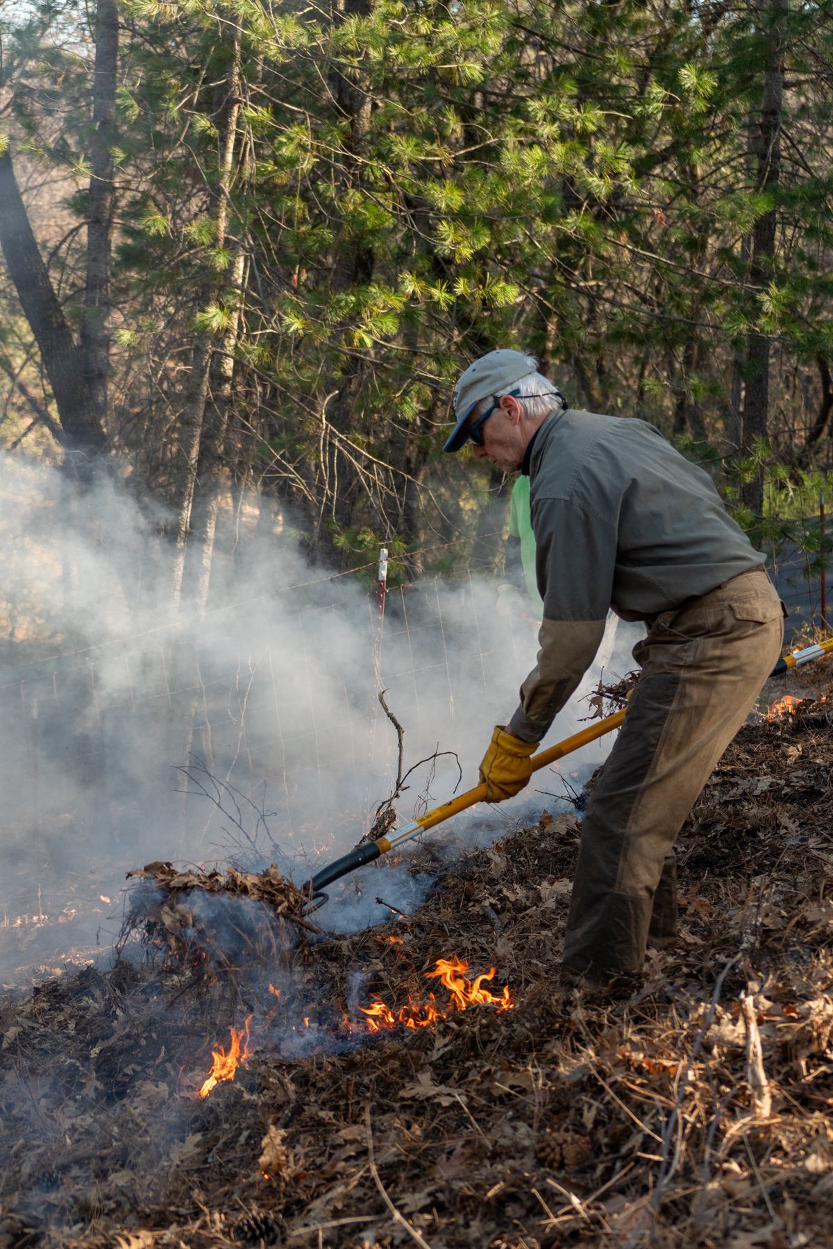 A person tending a broadcast burn.